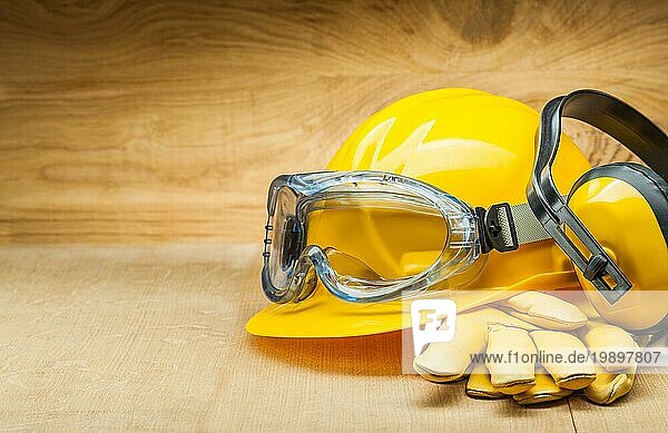 Sicherheitskonzept. Sicherheitswerkzeuge für den Bau. Gelber Bauhelm  Lederhandschuhe und Kopfhörer