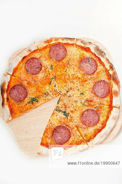 Italienische Original Peperoni Pizza mit dünner Kruste  vor weißem Hintergrund  Lebensmittelfotografie
