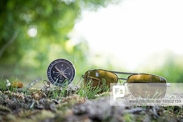 Vintage Kompass und Sonnenbrille auf dem Boden liegend. Abenteuer und Entdeckung Konzept
