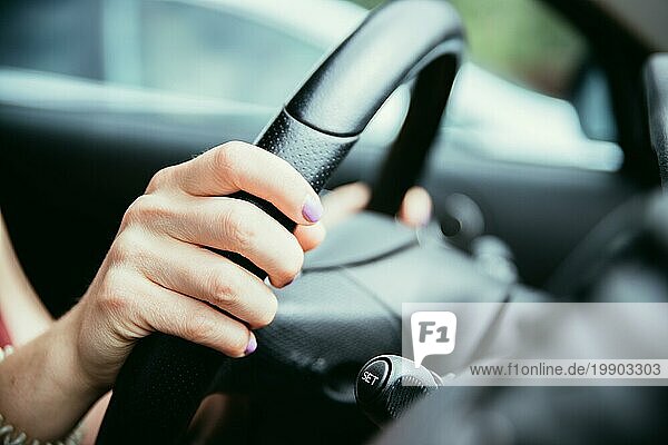 Weibliche Hände am Lenkrad eines Sportwagens  Autoinnenraum