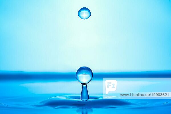 Wassertropfen spritzt in blaue Wasseroberfläche Gesundheit und Reinheit Konzept