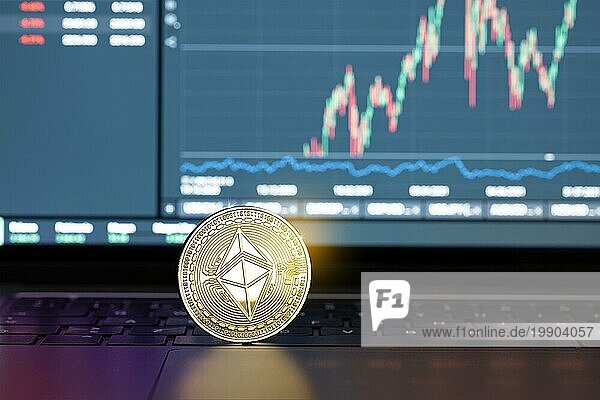Ethereum Münze auf Laptop und Chart auf dem Display im Hintergrund. Cryptocurrency Handel oder Investitionen Konzept