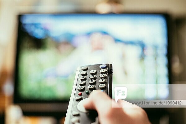 TV Fernbedienung im Vordergrund  Fernseher im unscharfen Hintergrund. Filmabend mit Vod Streaming