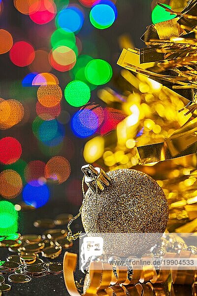 Gold Weihnachtskugel auf dem Hintergrund der dunklen Bokeh