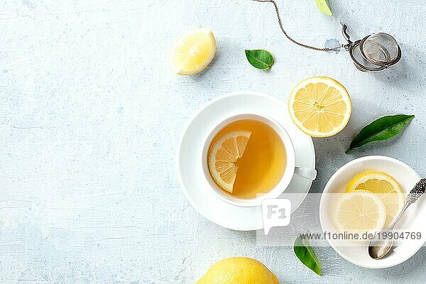 Zitronentee in einer Tasse  Aufnahme von oben mit Kopierraum. Biozitronen grüne Blätter und das natürliche Heilmittel des gesunden Getränks