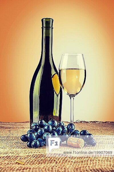 Flasche Wein und Weinglas mit Zweig der Traube auf Sackleinen instagram Stil