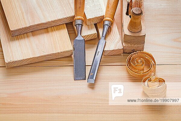 Komposition von Holzbearbeitungswerkzeugen Zimmermannsmeißel und Hobel auf Holzplatten