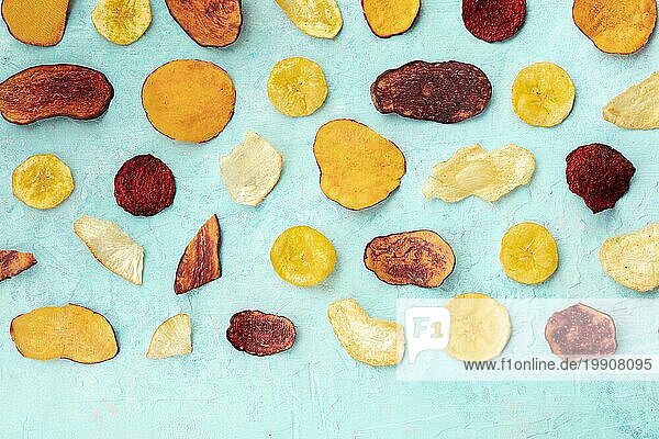 Trockene Obst und Gemüsechips  gesunder veganer Snack  ein Bio Lebensmittel Flat Lay Muster auf einem blaün Hintergrund mit Kopierraum