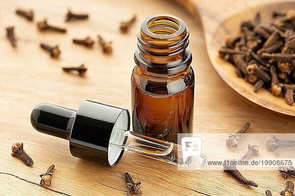 Ätherisches Nelkenöl in einer Flasche auf einem Holztisch. Alternative Medizin