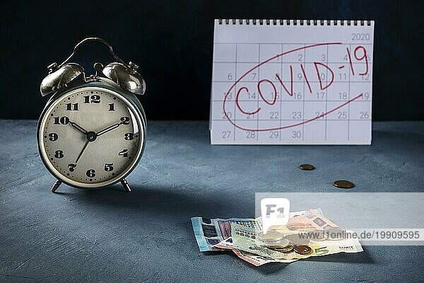Auswirkungen des Covid19 auf die europäische Wirtschaft  wirtschaftliche Folgen des Quarantänekonzepts. Eine Uhr  ein Monatskalender und der letzte gesparte Euro