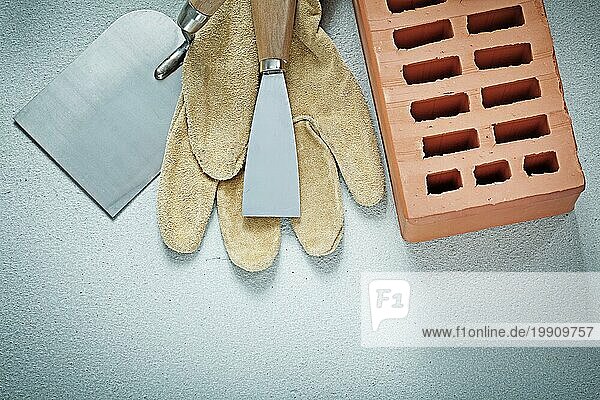 Construction Ziegel Schutzhandschuhe Farbe Schaber auf Betonoberfläche Maurerarbeiten Konzept