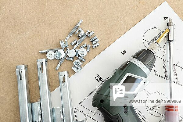 Draufsicht auf einen Akkuschrauber  Schubladengleiter  Schrauben und Zubehör. Konzept für den Zusammenbau von Möbeln. Raum kopieren