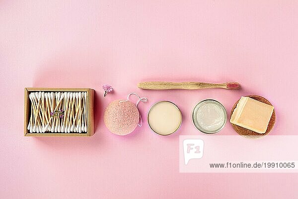 Plastikfreie  abfallfreie Kosmetika  flach gelegt auf einem rosa Hintergrund. Bambuszahnbürste Wattestäbchen  Konjac Schwamm  natürliche Bio Produkte mit Copyspace