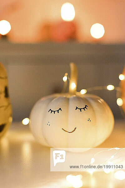 White pumpkin decorated with string light on table