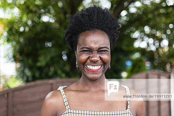 Happy young woman with afro hairstyle in park