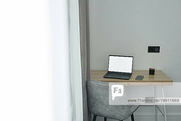 Wooden table with wireless laptop on it at home office