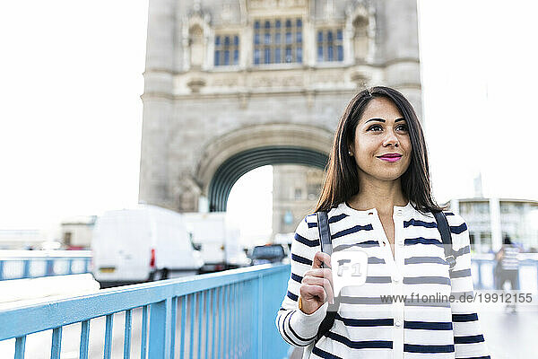 Smiling woman standing on Tower Bridge in city of London