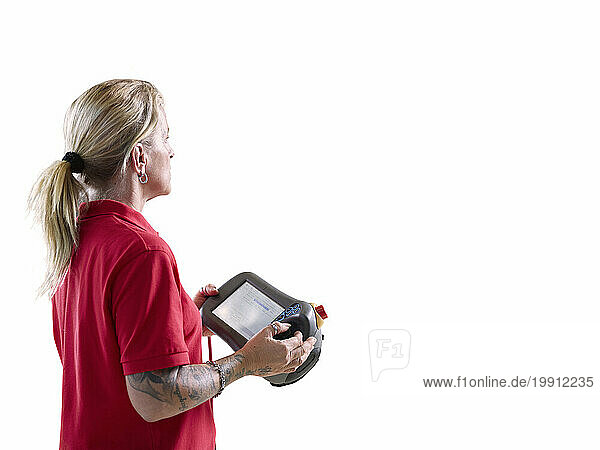 Technician standing with tablet PC and controller against white background