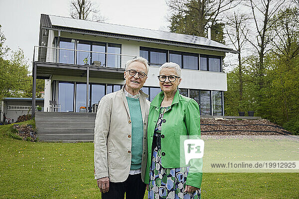 Portrait of senior couple in front of their home