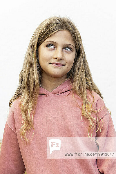 Smiling blond girl with long hair against white background