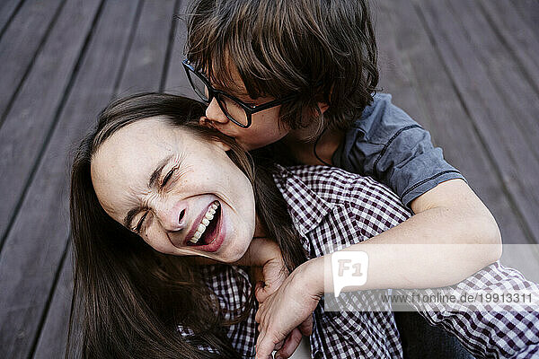 Playful boy embracing and kissing mother