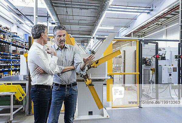 Businessman discussing with colleague in factory