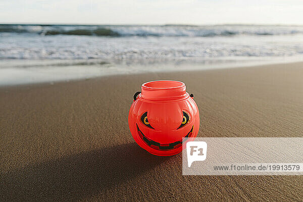 Halloween pumpkin toy on sand at beach