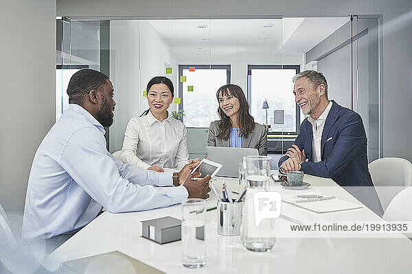 Happy business people having discussion at desk in office
