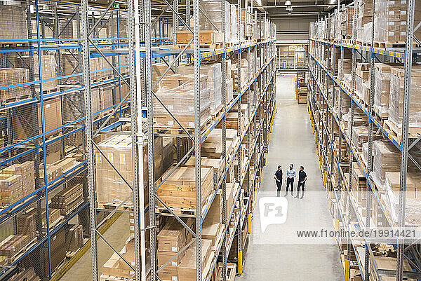 Businessman with colleagues having discussion in warehouse
