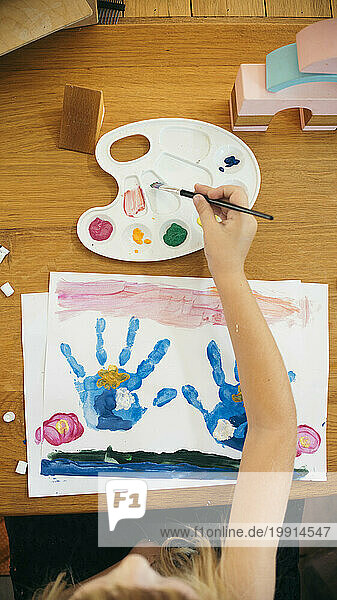 Girl painting with watercolor at home