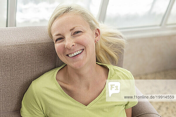 Happy woman relaxing on sofa at home