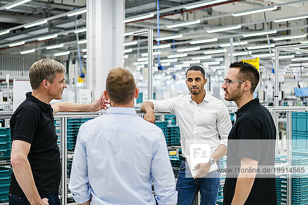 Businessmen and employees having a meeting in a factory