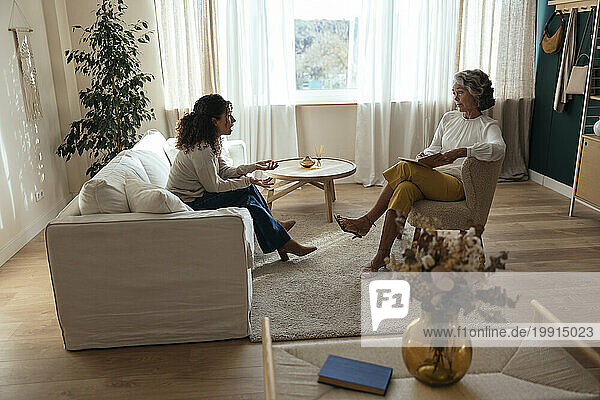 Woman having therapy session with psychologist at home