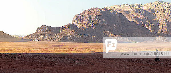 Panoramic of man wearing black  walking in the desert  Wadi Rum