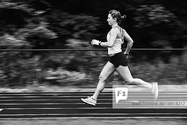 Female athlete running on track  Lincoln  Massachusetts  USA