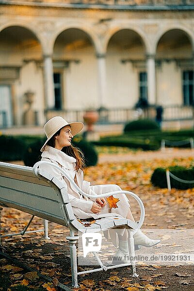 Young woman sitting on a bench in Prague autumn park