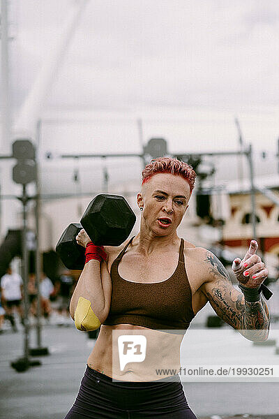 Women's CrossFit competition. Woman with dumbbells.