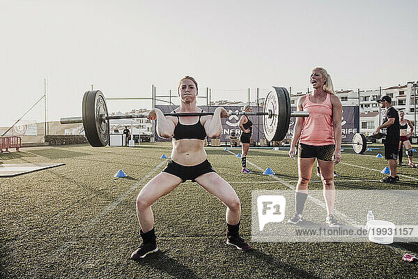 Female cross training athlete lifting barbell