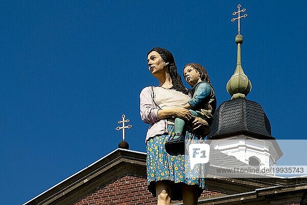 Figuren Mutter und Kind vor einer Kirche