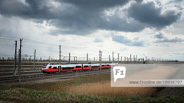 Zug auf einer Eisenbahnstrecke mit dramatischen Wolken