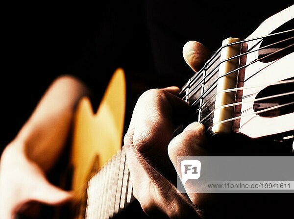 Flamenco Gitarrist Nahaufnahme  spielt traditionelle akustische Gitarre Konzept Bild uns als Hintergrund  hoher Kontrast  selektiver Fokus auf Vordergrund Finger