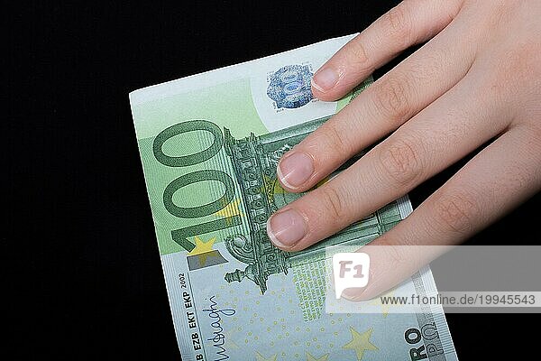 Hand hält 100 Euro Geld Bargeld vorschwarzem Hintergrund