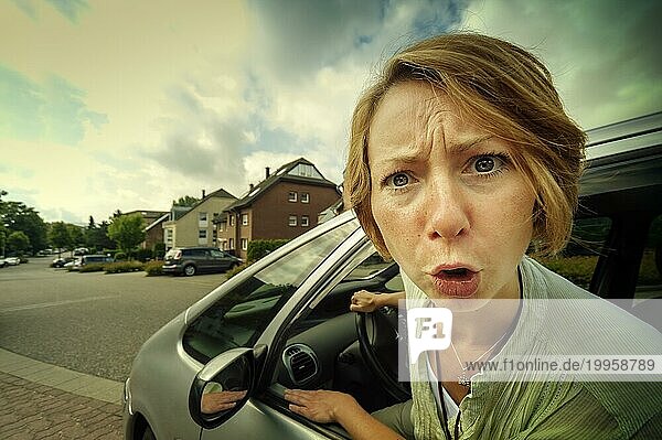 Wütende PKW-Fahrerin steckt den Kopf aus dem Fenster