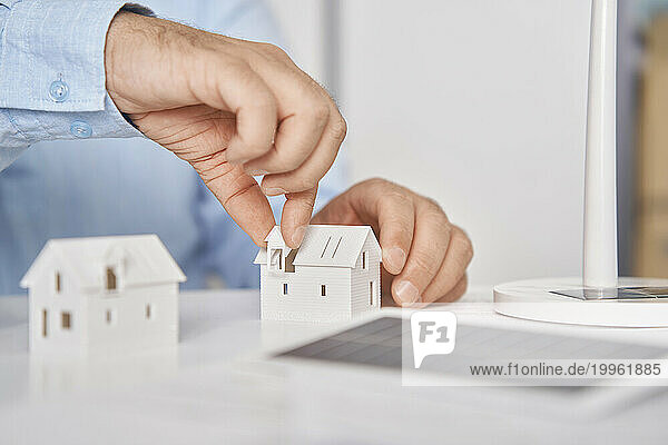 Hands of architect working on house model in office