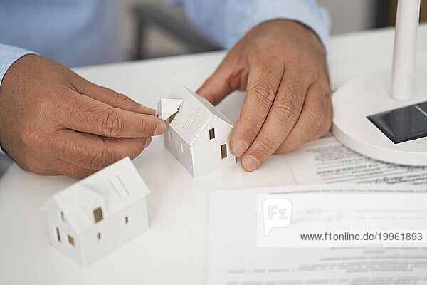 Architect working with house model at desk in office
