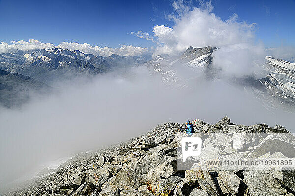 Austria  Tyrol  Female hiker ascending rocky slope of Hoher Riffler with thick fog in background