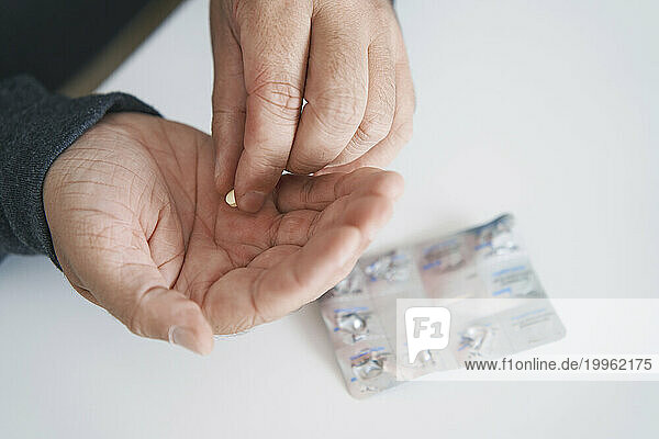 Man taking medicine at table