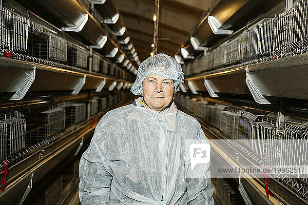 Veterinarian standing near birdcages in factory