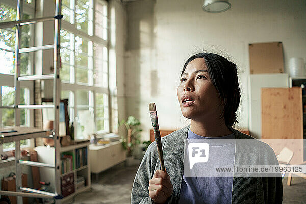 Painter holding paintbrush at art workshop
