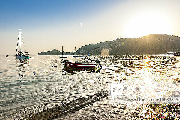 Greece  Ionian Islands  Agios Georgios  Boats in front of Agios Georgios Pagon beach at sunset
